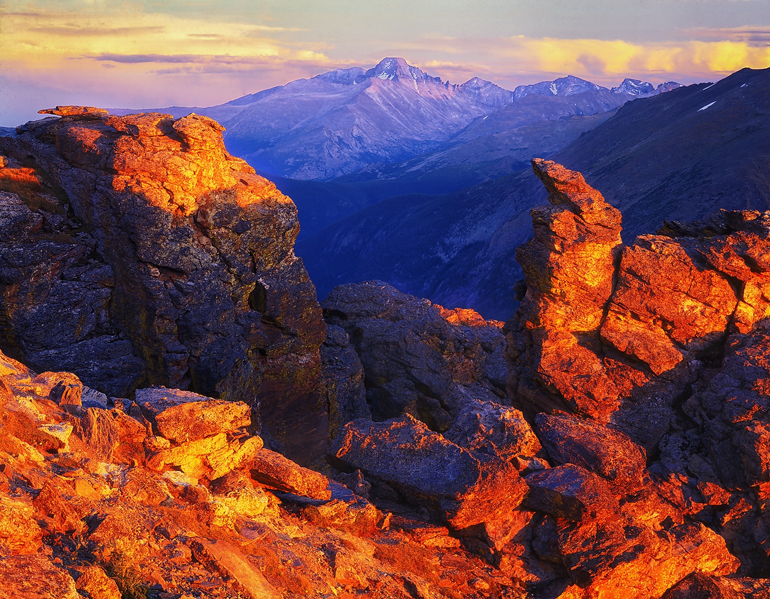Sunset illuminates Rock Cut along Trailridge Road framing Long's Peak (14,259 ft - 4346 meters)  in Colorado's Rocky Mountain National Park.